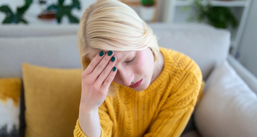 Sinus ache causing very paintful headache. Unhealthy woman in pain. Sharp strong sore. Sinus pain, sinus pressure, sinusitis. Sad woman holding her head because sinus pain